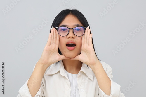Bild auf Leinwand A shocked and dumbfounded young Asian woman covers her face with her palms, looks at the camera with a funny expression, reacting to something very surprising, isolated on a white background