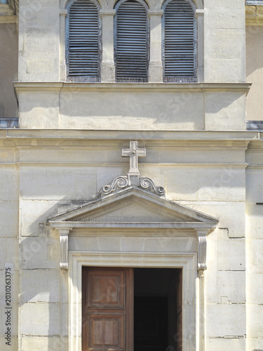 Принти на полотні Classical French Church Entrance with Stone Pediment, Cross and Wooden Door