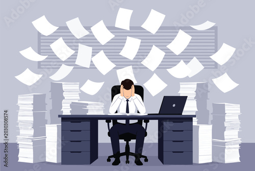 Overwhelmed businessman sitting at a desk with piles of work while numerous papers fly through the air around him in a panic.