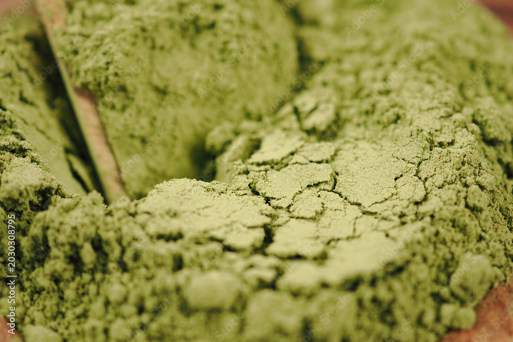Fototapeta premium Green powder lies on a wooden surface