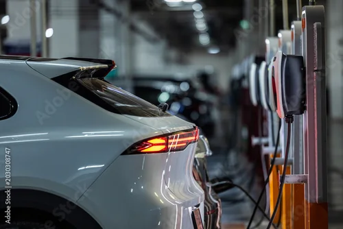 Obraz  z motywem Autonomous EV car charging at AC power station. Self driving vehicle.