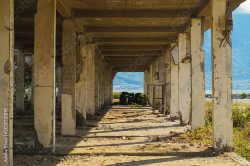 Abandoned concrete pillars line a broken hallway