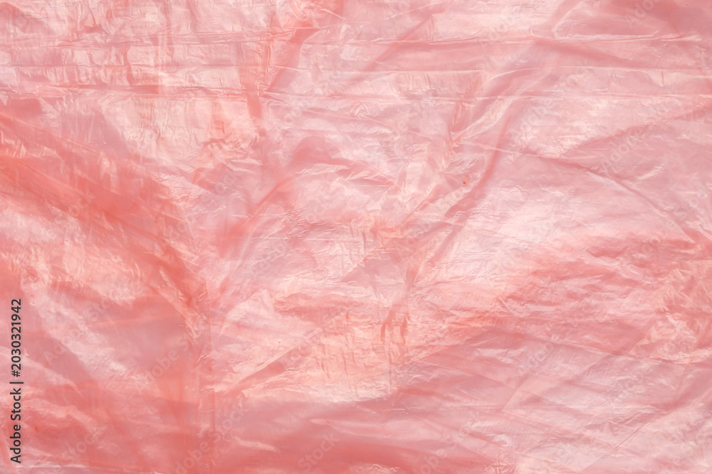 Fototapeta premium Crumpled red plastic texture, wrinkled polyethylene bag surface background