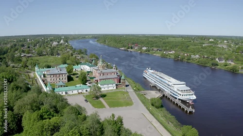 Orbital aerial footage of Nikolsky monastery and cruise ship on Volkhov river on sunny summer day. Staraya Ladoga, Russia.