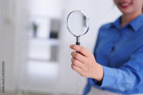 Asian business women holding magnifying glass search analysis research investigate inspect examine data information detail discovery office workplace
