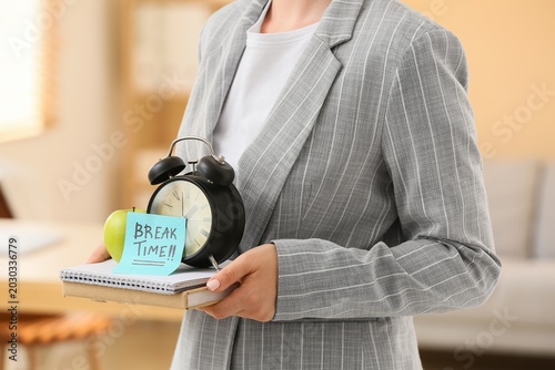 Businesswoman holding alarm...