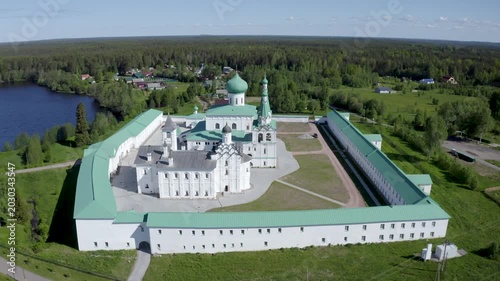 Orbital aerial shot of Alexander-Svirsky Monastery and Roshchinskoe lake on sunny summer day. Leningrad Oblast, Russia.