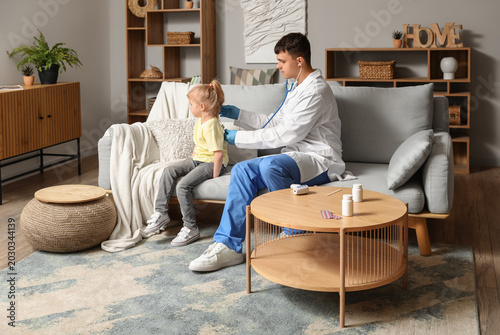 Male pediatrician examining...