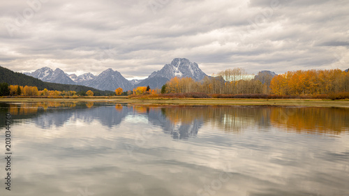 Tableau sur toile Wide angle scenic view of Mount Moran and golden fall foliage under an overcast