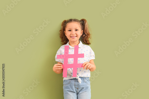 Cute little girl with hashtag on green background