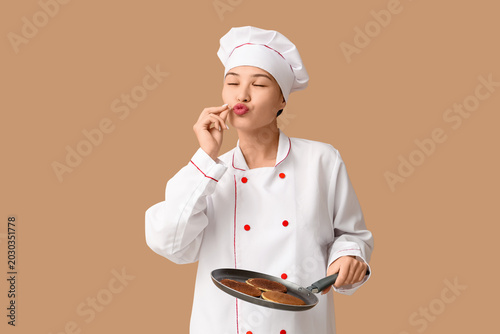 Young Asian female chef hol...