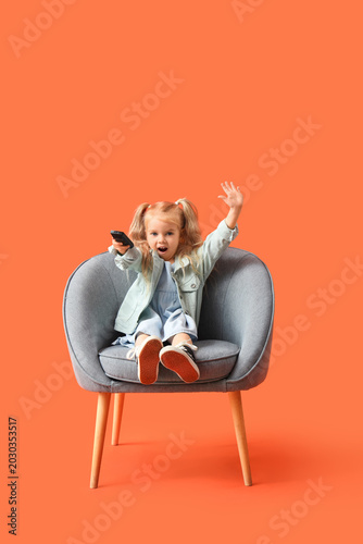 Little girl in armchair wat...