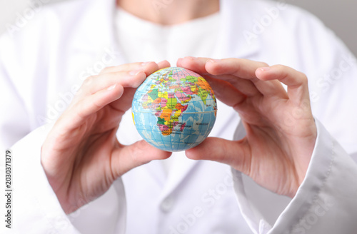 Cuadro en lienzo Doctor in white medical gown holding globe model