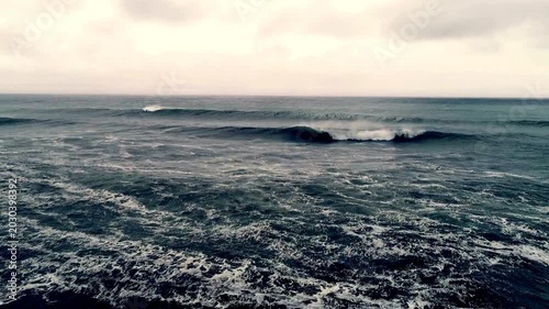 Dark blue ocean waves under a foggy sky with white foam sea horizon. Atmosphere and naturethemed design elements. Suitable for backgrounds and web graphics.