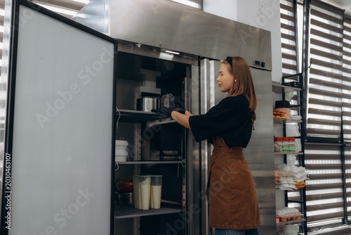 Canvas Print Pastry chef organizing professional kitchen refrigerator storage