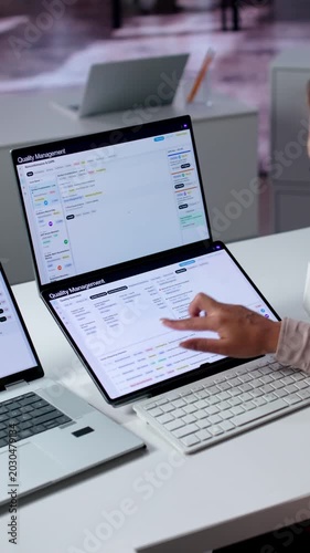 Quality Manager Reviews Corrective Action Reports On Laptop