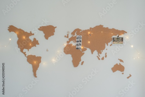 World map with location pins marking destinations on wooden surface with soft light