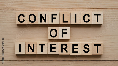 A wooden background with conflict of interest blocks arranged in a neat pattern