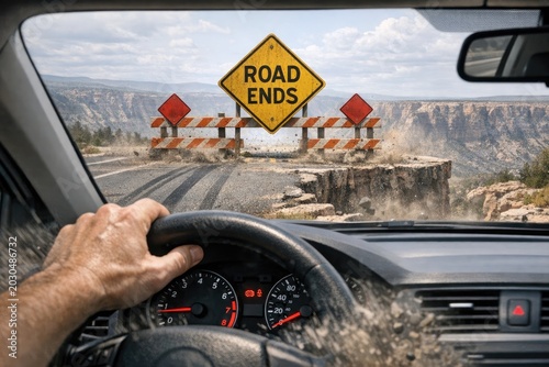 A person driving a car on a road that ends, with a visible road end sign