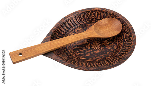 Wooden spoon rests on a decorative, carved wooden spoon holder