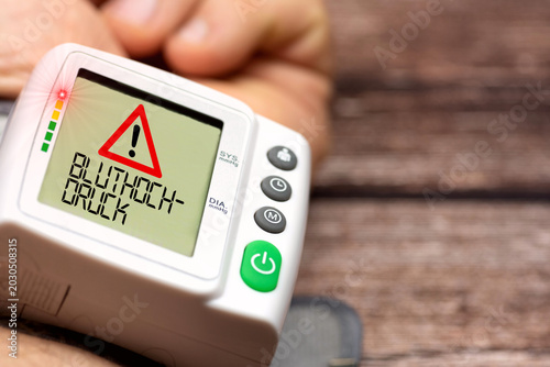 Blutdruckmessgerät am Handgelenk und Hinweis auf Bluthochdruck