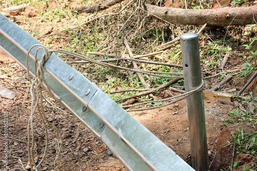 Canvastavla Closeup of weathered metal guardrail tied with rope to steel pole
