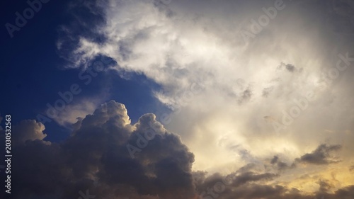 sky background, The slightly cloudy afternoon sky with black clouds highlighted by the yellow afternoon sunlight looks beautiful and dramatic.