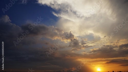 sky background, The slightly cloudy afternoon sky with black clouds highlighted by the yellow afternoon sunlight looks beautiful and dramatic.