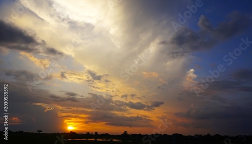 beautiful and dramatic afternoon sky with blackened white clouds and orange afternoon sunlight
