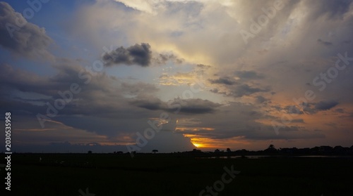 beautiful and dramatic afternoon sky with blackened white clouds and orange afternoon sunlight