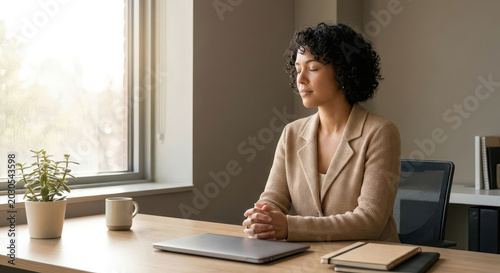 Woman in professional attire taking a moment of solitude at her workspace