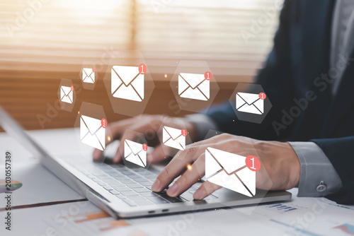 Email notification and digital communication concept with business professional typing on laptop. Online messaging, inbox alert, email marketing, customer support and modern communication technology.