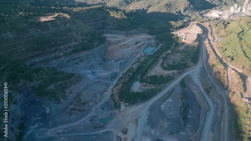 Massive open pit mining complex spreads near Fercal, Brasília, Federal District, Brazil, top down overhead drone yaw reveal terraced excavation systems, haul road networks, engineered extraction scape