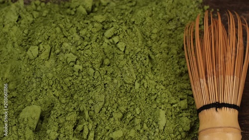 Matcha green tea powder with a whisk for whipping, slider view