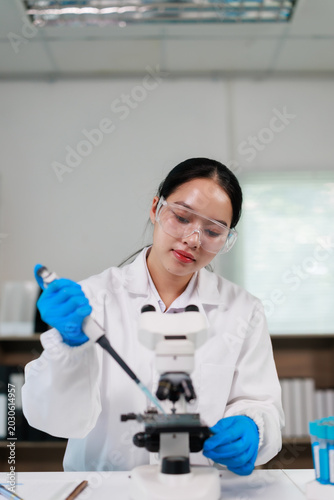 Bild auf Leinwand Female Asian scientist in white lab coat