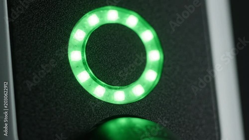 Close Up View of Green LED Ring Indicator Light on Black Textured Panel Modern Technology Device Interface