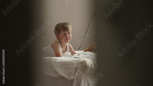Mother feeding little boy breakfast in bed