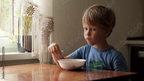 Young boy eating cereal for breakfast at home
