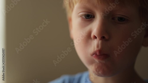 Adorable blond boy eating cereal for breakfast