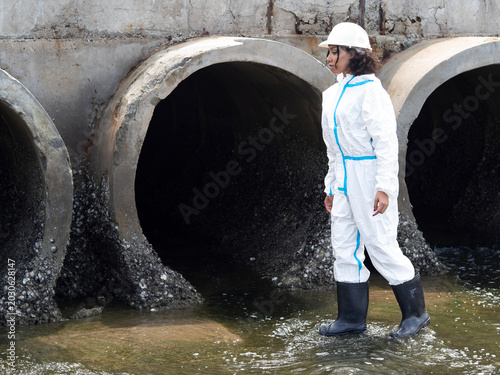 Photos Environmental engineers in chemical protective suits are collecting samples of contaminated water, ecologically and industrially, from nearby areas for testing