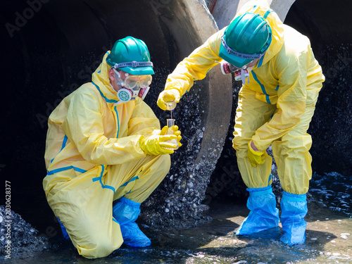 Photos Environmental engineers in chemical protective suits are collecting samples of contaminated water, ecologically and industrially, from nearby areas for testing