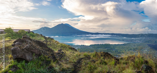 Obraz na płótnie Panoramic sunrise view of Mount Batur, Lake Batur and black lava landscape in Ki