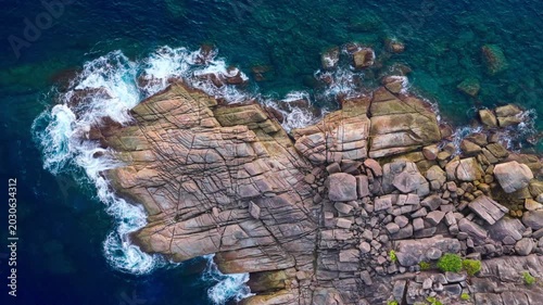 Aerial top view of a tropical paradise beach island with green forest eco system and crystal clear turquoise water and white sand beach background	