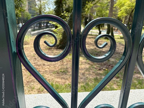 A sturdy black metal fence runs along the sidewalk.