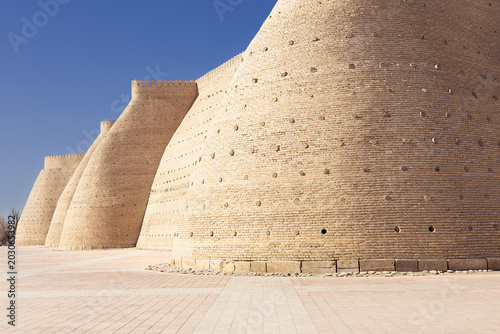 Foto Ark Fortress walls in Bukhara with massive curved brick bastions under clear blue sky