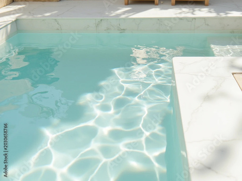Sunlight filters through pool water and reflects on marble surroundings