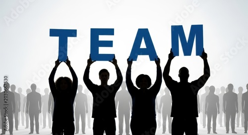 Silhouettes of diverse people holding up blue letters spelling team concept with teamwork