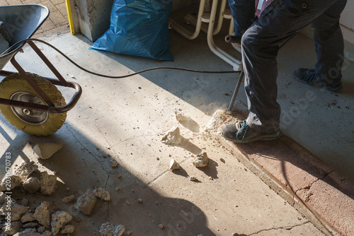 Konstfotografi Worker using jackhammer to break concrete floor during renovation