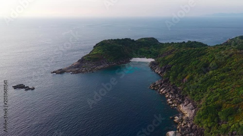 Aerial view of a tropical paradise beach island with green forest eco system and crystal clear turquoise water and white sand beach background	