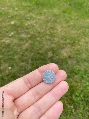 Mano che regge una moneta